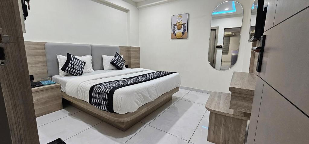 a bedroom with a bed and a mirror on the wall at Hotel HR Sky in Ahmedabad