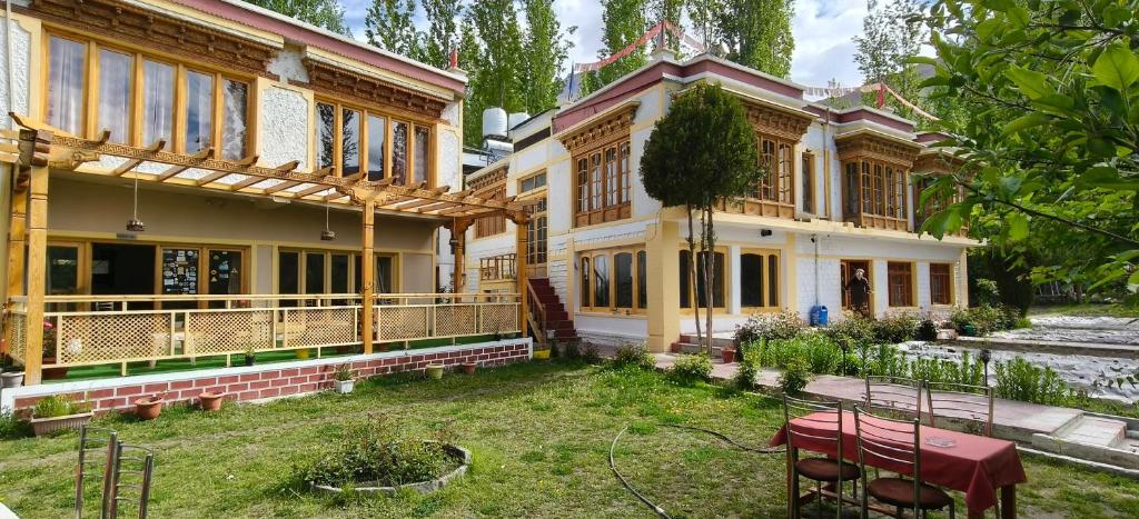 a large house with a yard in front of it at Hotel Namgyal Villa in Nubra