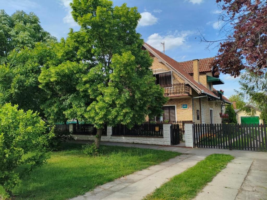 a house with a fence and a tree at Smeštaj Mevlida in Belo Blato