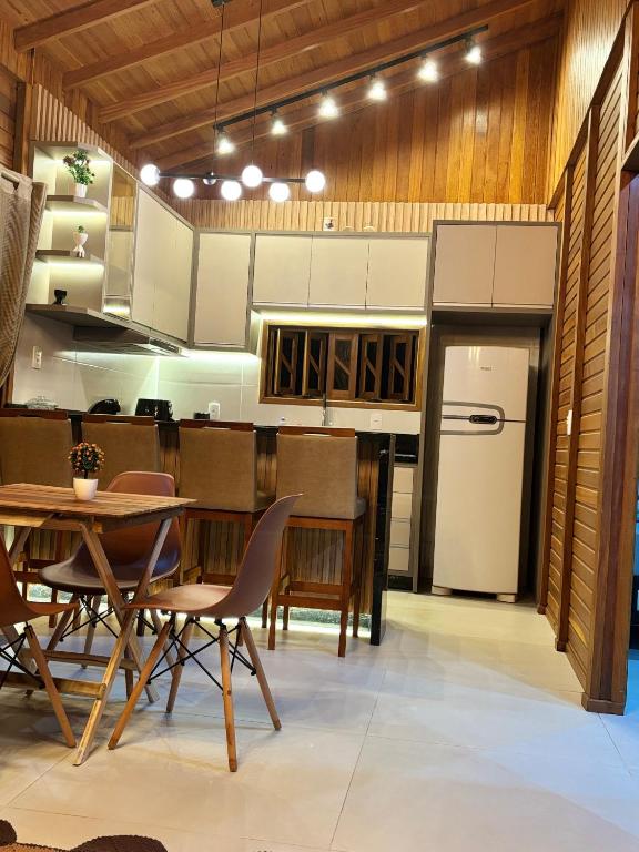 a kitchen with a table and chairs and a refrigerator at HolzHaus em Pomerode in Pomerode