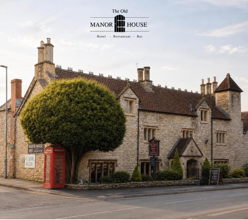 a building with a red phone booth in front of it at The Old Manor House Hotel in Keynsham