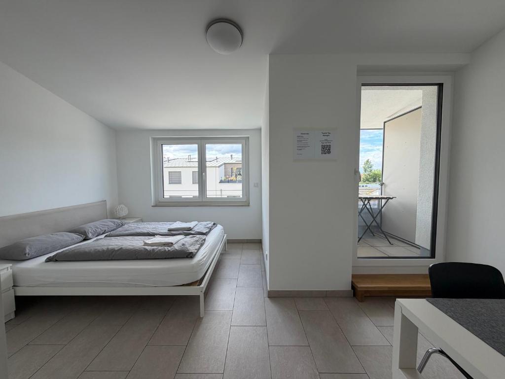 a white bedroom with a bed and a mirror at Guestroom Hannover Messe in Hannover
