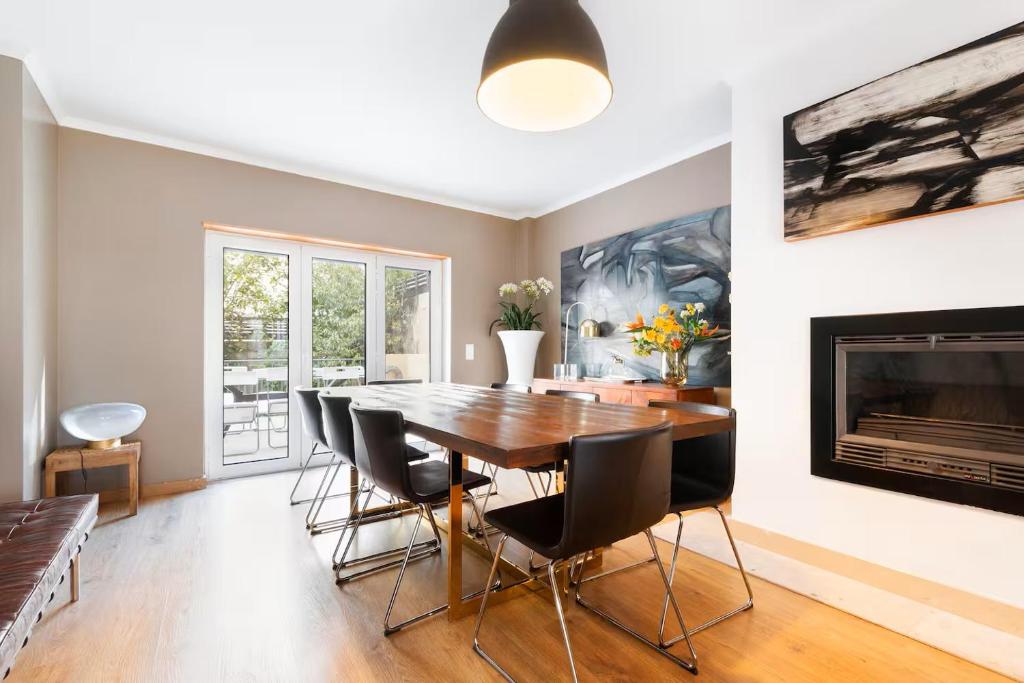 a dining room with a table and chairs and a fireplace at Exquisite Townhouse in Lisbon City Center- PRIVATE GARAGE & TERRACE in Lisbon