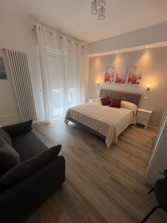 a bedroom with a bed and a couch at Casa Ezio beach&relax in Chioggia