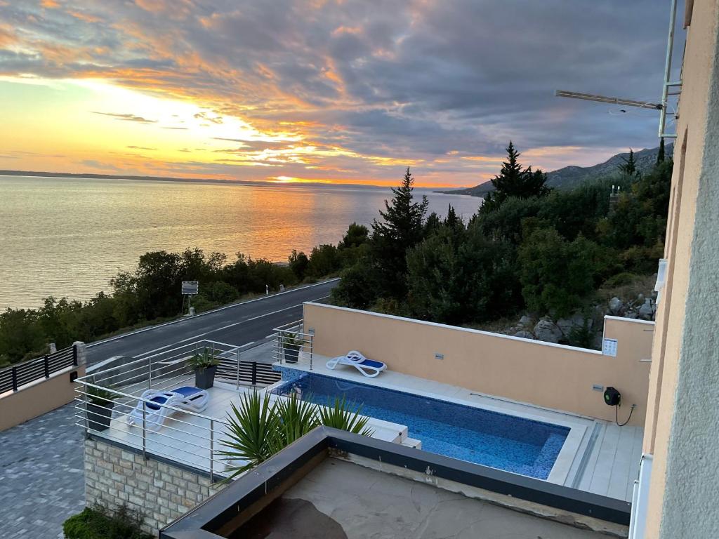 a villa with a swimming pool and a sunset at Villa Luna Maris in Starigrad