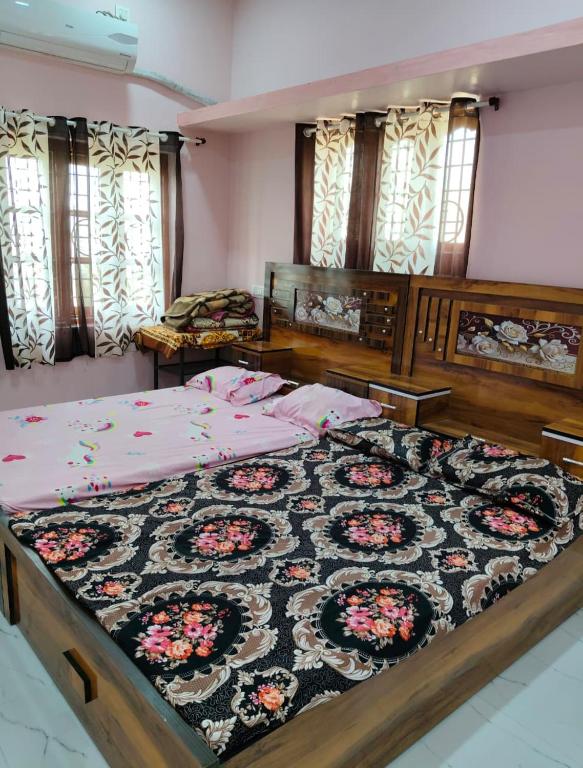 a bedroom with two beds with a rug on it at Swami's Yatri nivas in Akalkot