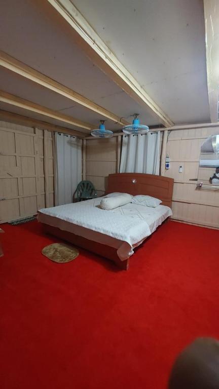 a bedroom with a large bed on a red carpet at Keyangjhiri Eco Resort, Lama, Bandarban in Bāndarban