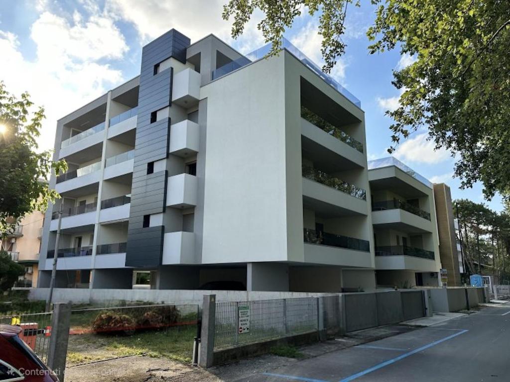 an apartment building with a white facade at Cozy flat 300m from the beach in Bibione