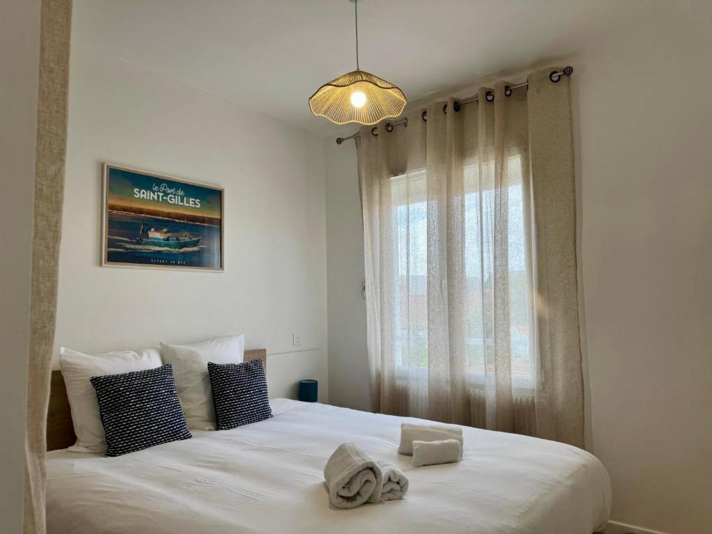 a bedroom with a large white bed with a window at Les Cabines de la Vie in Saint-Gilles-Croix-de-Vie