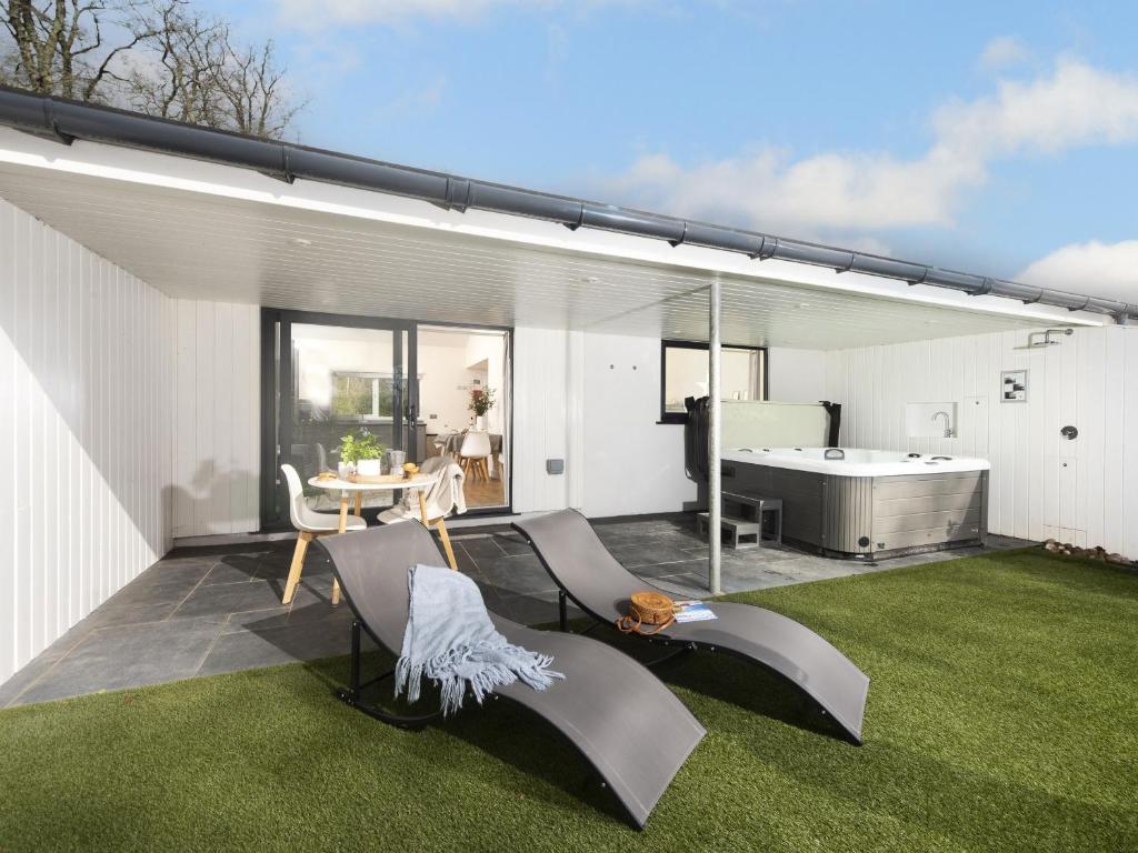 a patio with a tub and green grass at Little Dunley Cottages - Hazel in Bovey Tracey