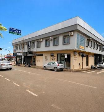 a car parked in front of a building on a street at Carmo Palace Hotel in Carmo do Paranaíba