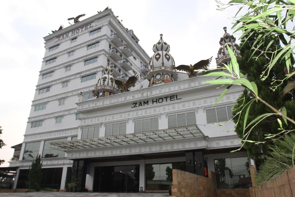 a large white building with a sign on it at Zam Hotel By Pavotel in Kedungbadak