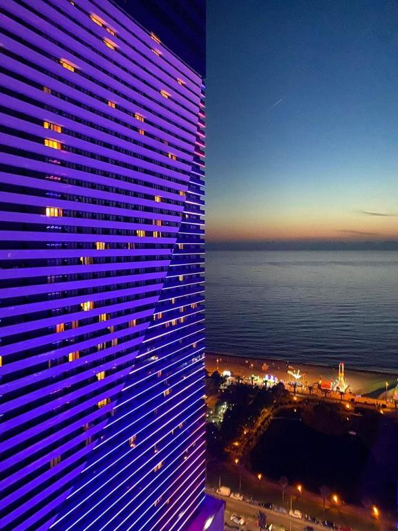 a view of a tall building next to the ocean at Orbi in Batumi 24 in Angisa