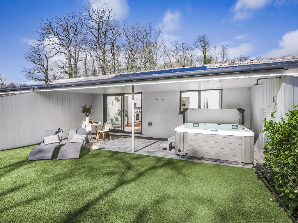 a backyard with a hot tub and a lawn at Little Dunley Cottages - Willow in Bovey Tracey
