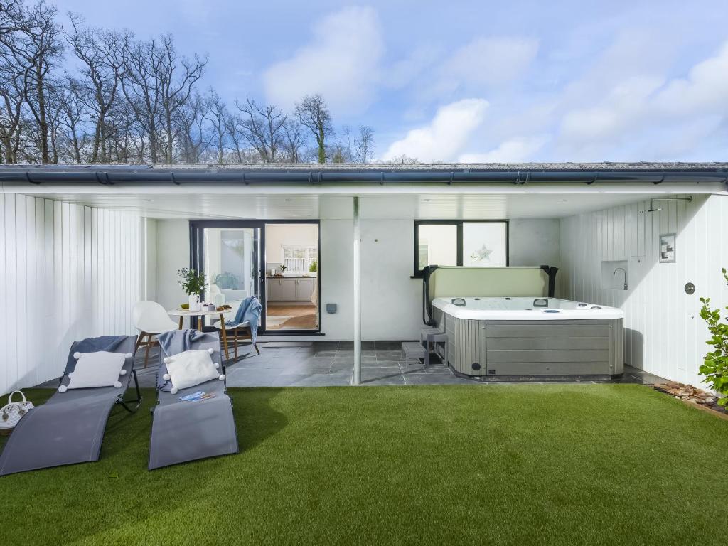 a backyard with a hot tub and a lawn at Little Dunley Cottages - Maple in Bovey Tracey