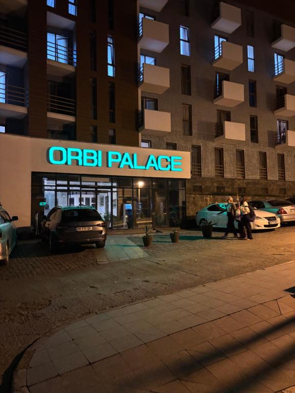 a parking lot with cars parked in front of an apartment building at Orbi Palace Bakuriani in Bakuriani