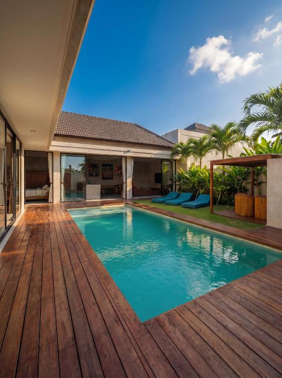 an image of a swimming pool with a wooden deck at Villa Donald in Canggu