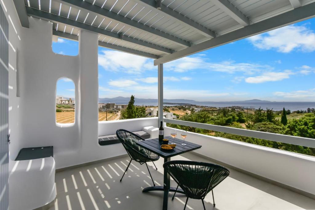 a balcony with a table and chairs and a view at Juniper View in Aspro Chorio Paros
