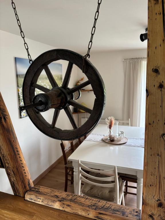 a wheel hanging from a chain in a dining room at Heckenstübchen in Simmerath