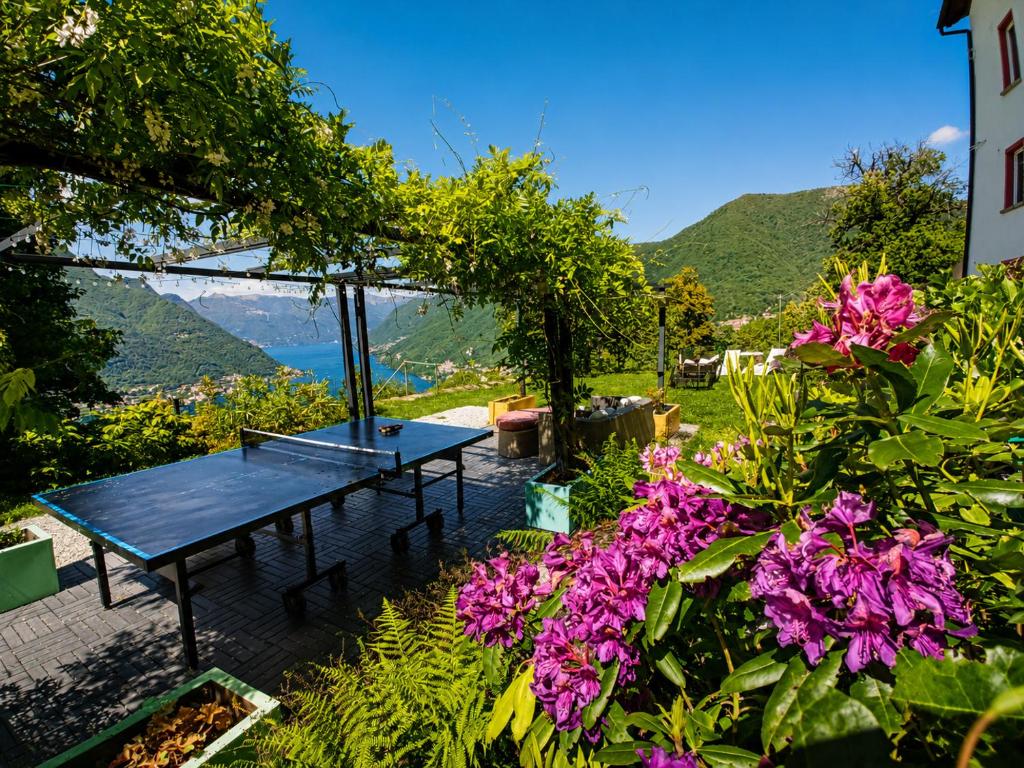a blue picnic table in a garden with flowers at Essentia Guest House in Faggeto Lario 
