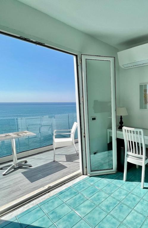 a room with a balcony with a view of the ocean at La Dimora sul Mare in Sant'Angelo D'Ischia