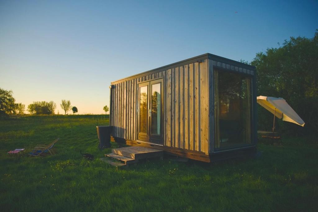 a small cabin in a field of grass at De IJsvogel in Wijdewormer