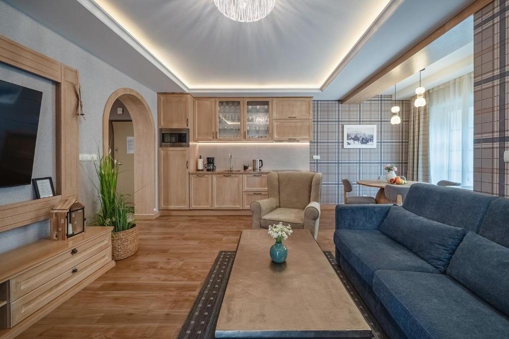 a living room with a blue couch and a tv at Rezydencja Sienkiewicza in Zakopane