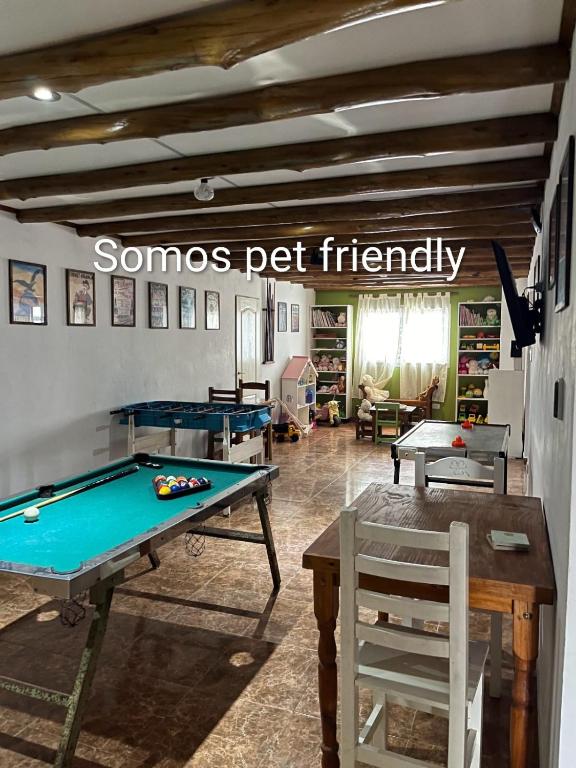 a room with a pool table and a sign that reads someone pet friendly at Ñande Roga San Cemente in San Clemente del Tuyú
