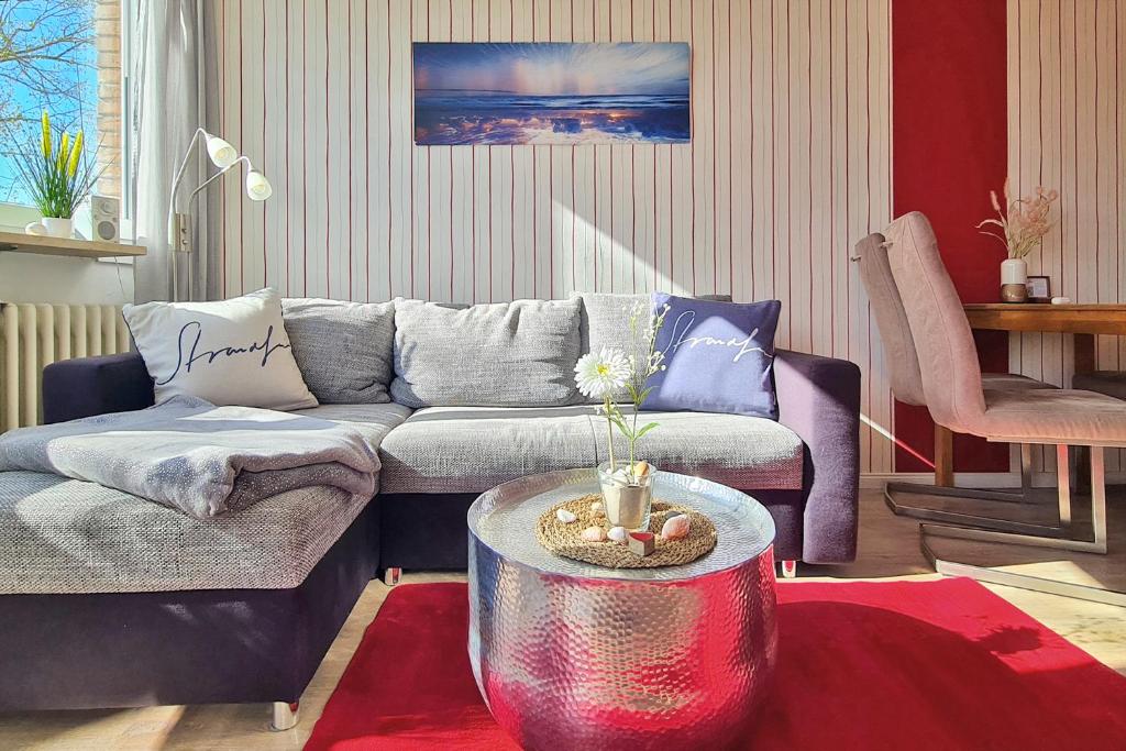 a living room with a couch and a table at Strandliebe in Scharbeutz, 150m zum Strand! Sonnenbalkon, ruhig gelegen, kostenfreier Parkplatz, Fahrstuhl in Scharbeutz