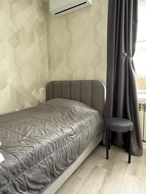 a bed and a chair in a room at Happy House in Karagandy