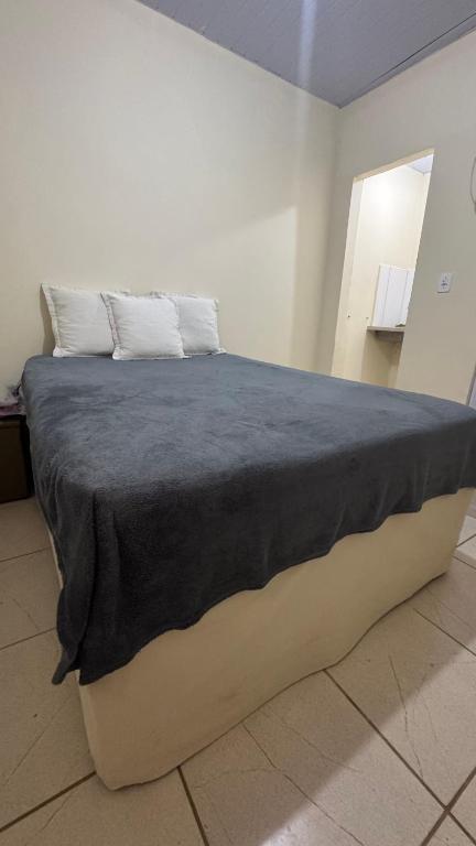 a large bed with a blue blanket on top of it at Na Ladeira Studio 02 in Rio de Janeiro