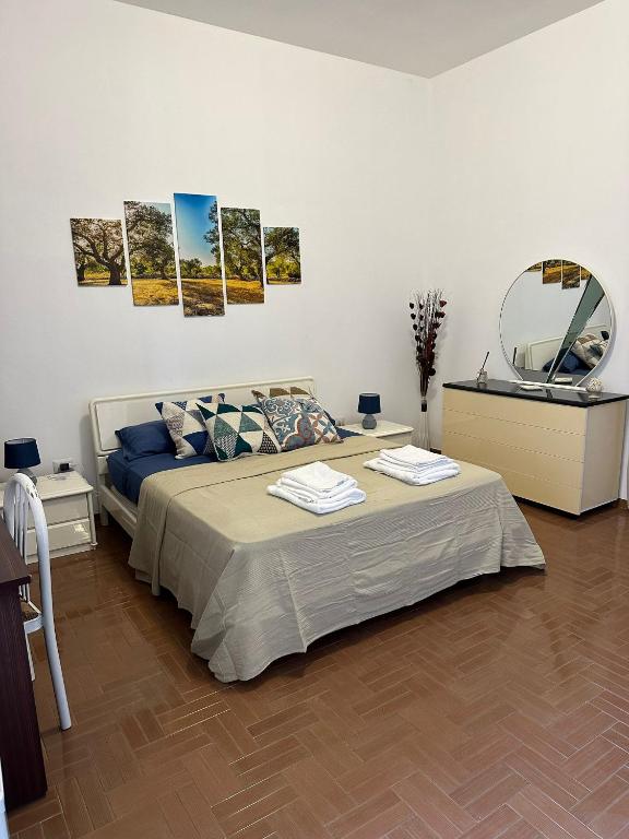 a bedroom with a large bed and a mirror at Affitto nel cuore del Salento in Poggiardo
