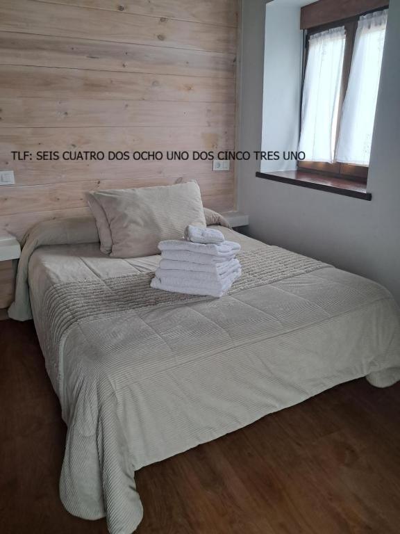 a bedroom with a bed with towels on it at Casa Elena in Cangas de Onís