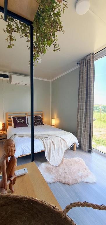 a bedroom with a bed and a large window at Free People Bungalow & Cort in Vama Veche