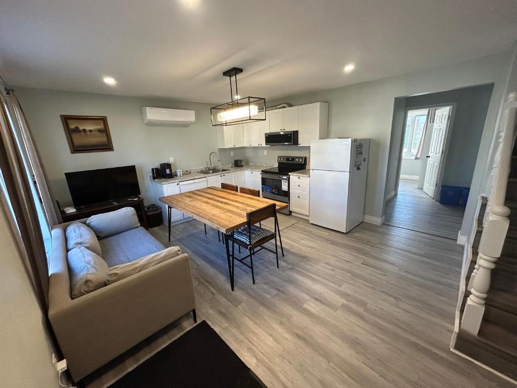 a kitchen and living room with a table and a couch at Modern Queen St Duplex 4BRs in Charlottetown
