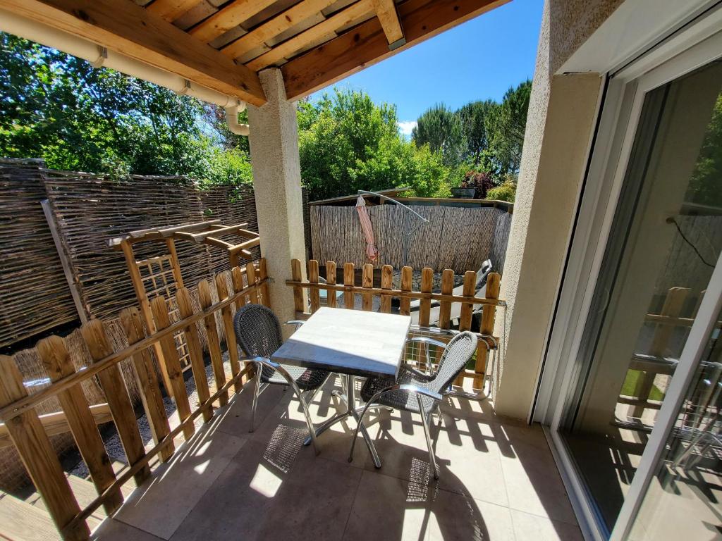 a patio with a table and chairs on a balcony at La casa Elisa Gîte T2 indépendant in Gréoux-les-Bains