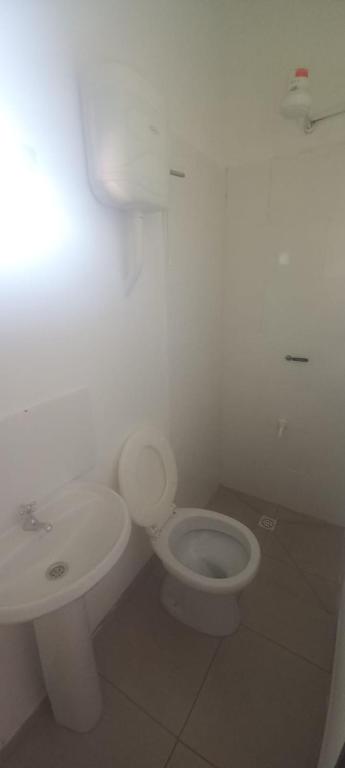 a white bathroom with a toilet and a sink at Juaky market y alojamiento in Garupá