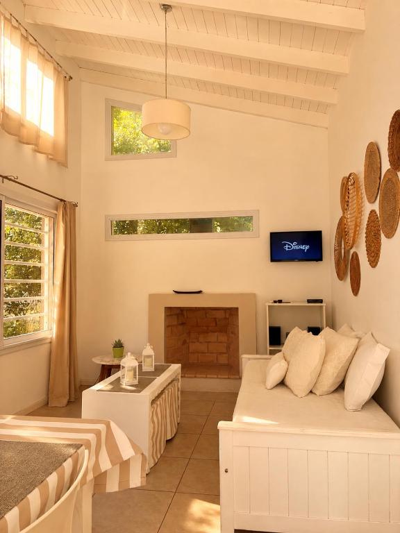 a living room with a bed and a fireplace at Cabañas Aires del Sur, con gran parque y pileta in Chascomús