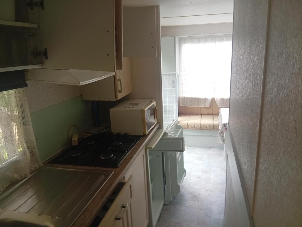 a small kitchen with a stove and a microwave at Camping les sumacs in Combles