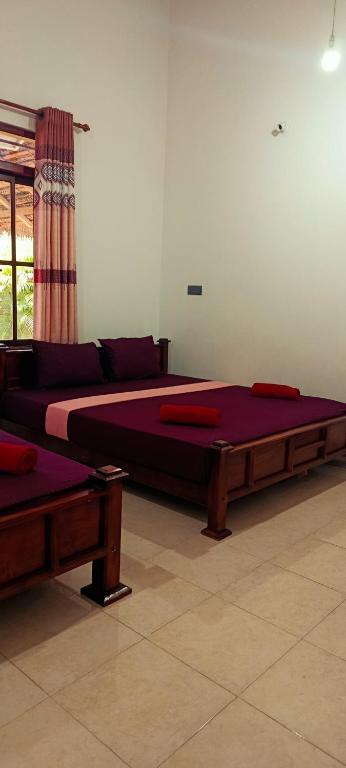 two beds are sitting in a room at MSM Surf Camp in Arugam Bay