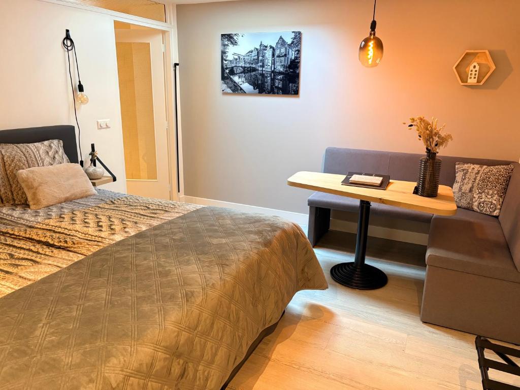 a bedroom with a bed and a table with a desk at Studio Schipper in Alkmaar