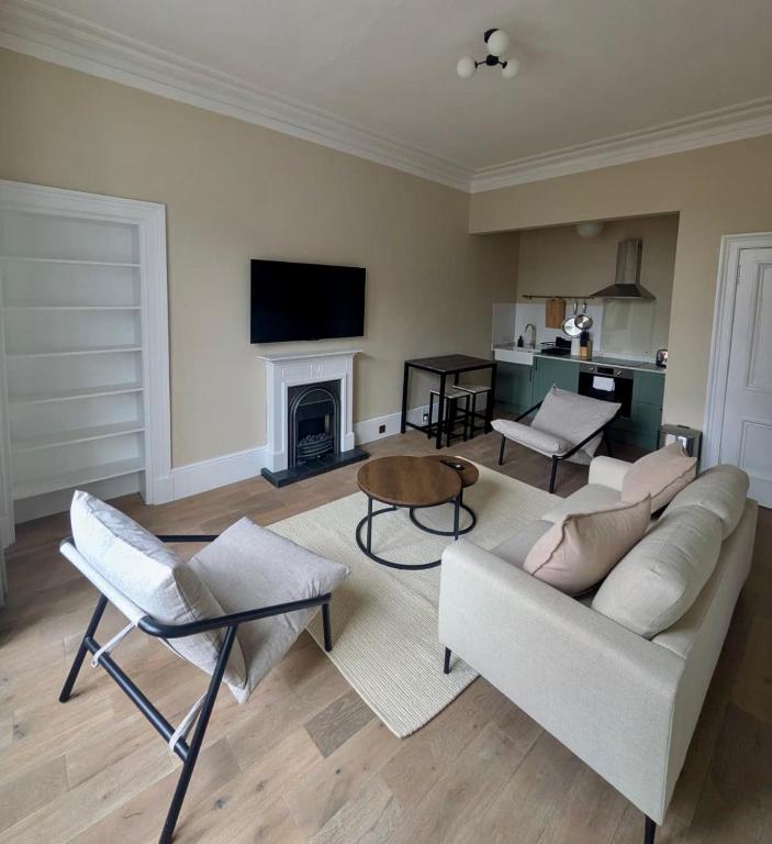 a living room with a couch and a fireplace at Modern Flat - Main St, Campbeltown in Campbeltown