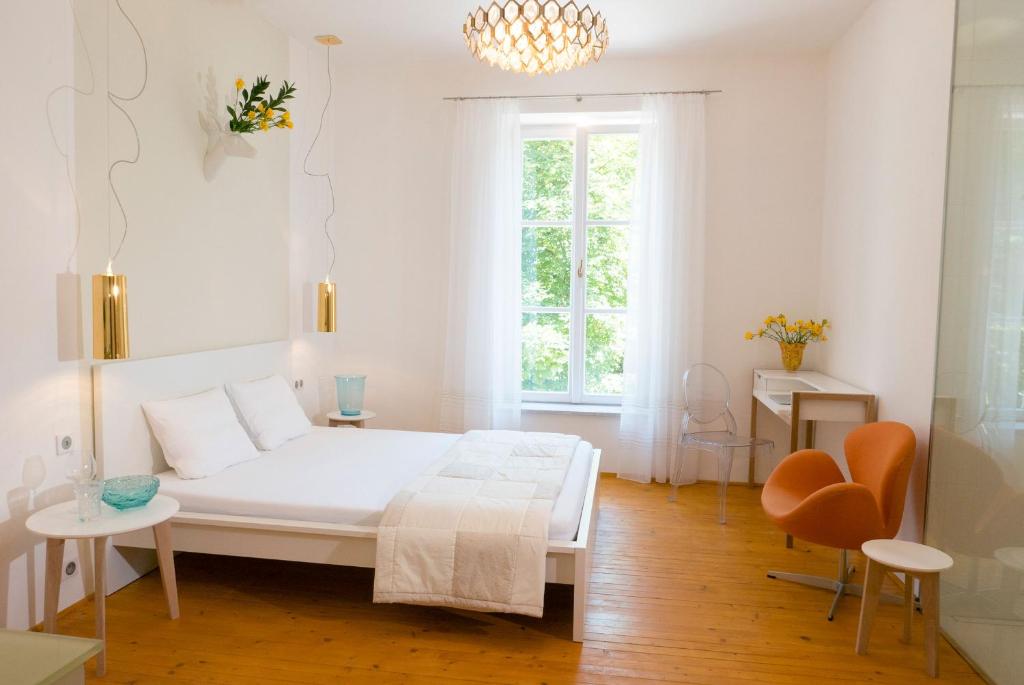 biała sypialnia z łóżkiem, stołem i krzesłami w obiekcie Design Apartments in Park w mieście Brno