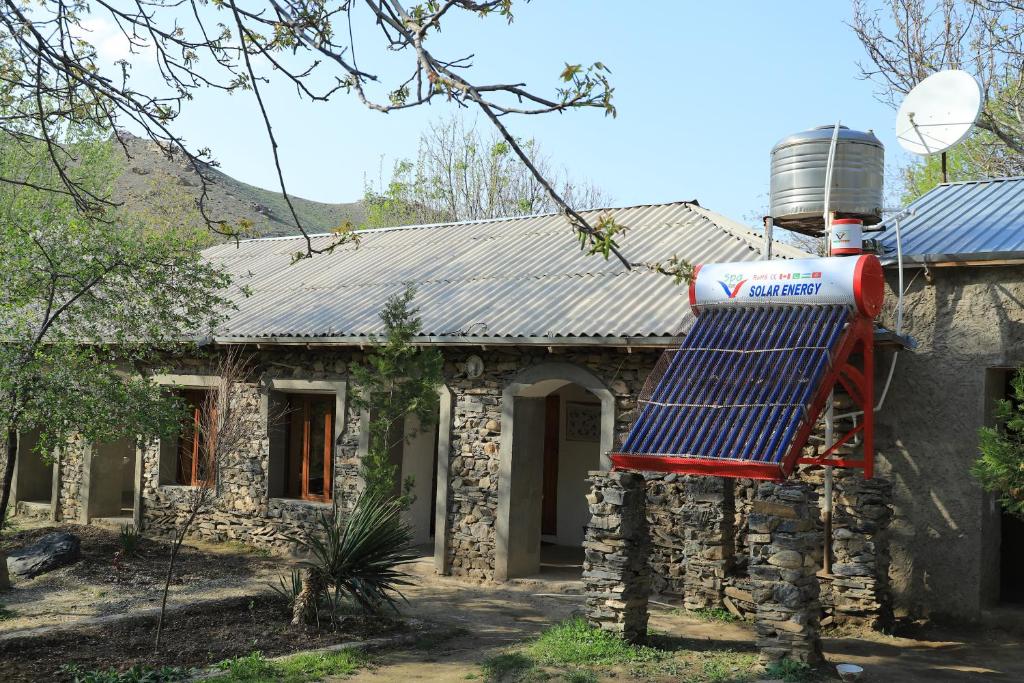 a house with a solar panel on the front of it at Rahima's Guest House in Tadzhimi