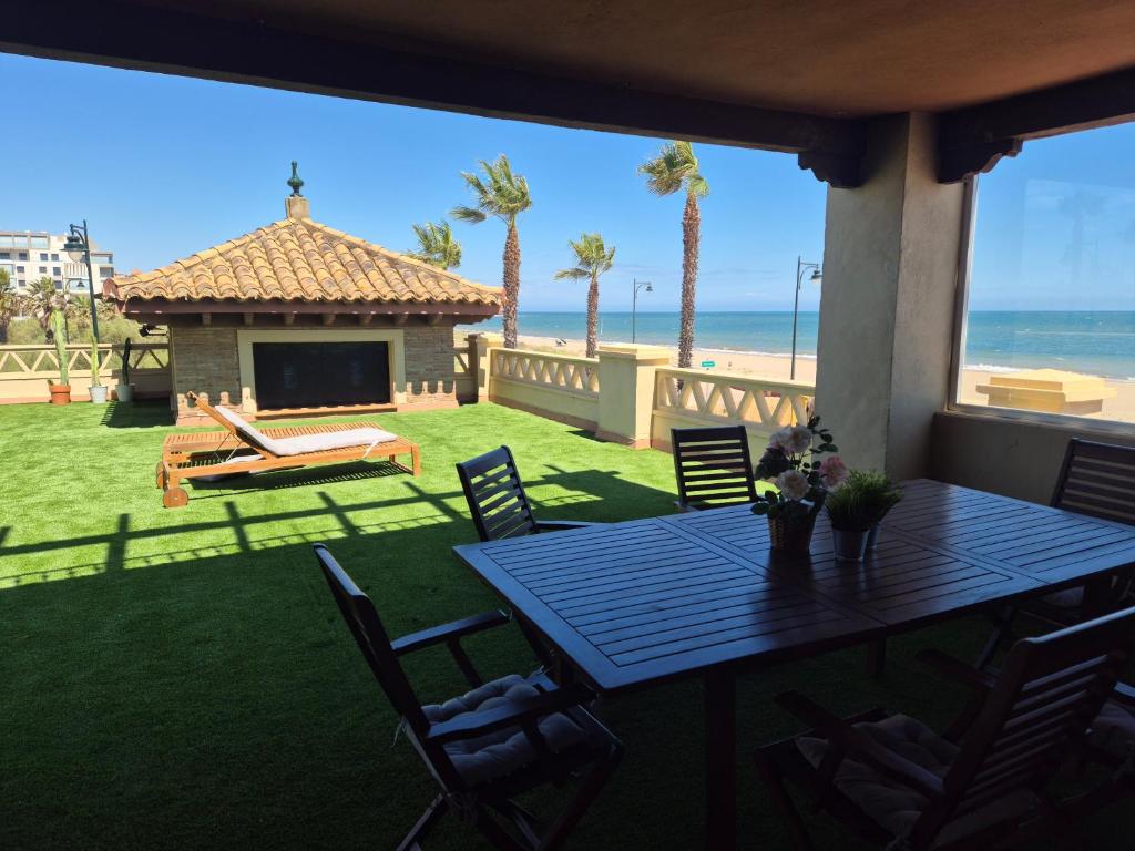 a table and chairs on a patio with the beach at TOP APARTMENT! Frente al mar y gran terraza in Ayamonte