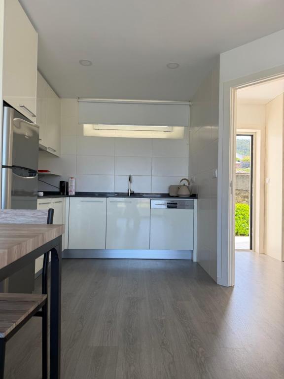 a kitchen with white cabinets and a wooden floor at AFIFE T1D Bouça Cabrita Residences in Afife