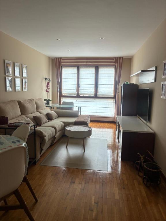 a living room with a couch and a tv at La Nala in Villaviciosa