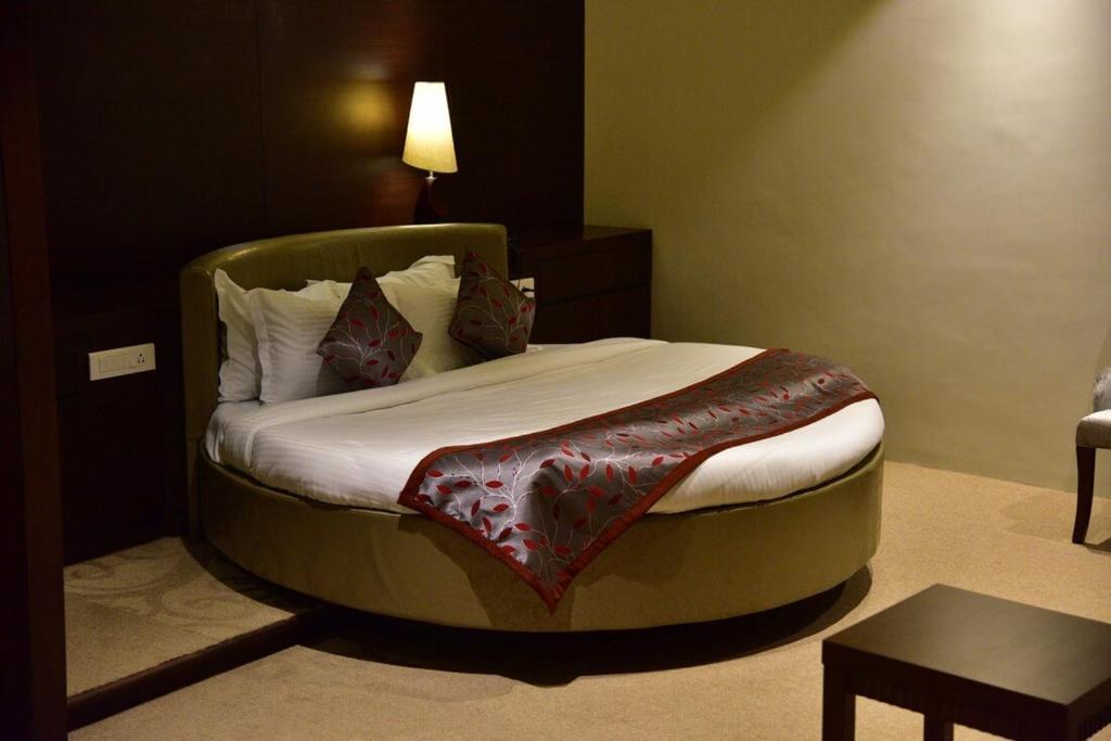 a bed in a hotel room with a round bedvisor at Chola Nest in Ariyalūr