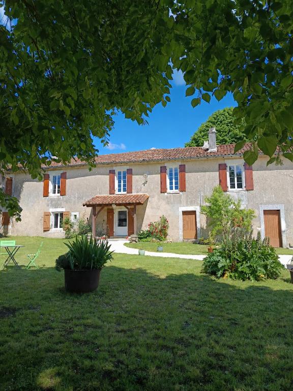 an exterior view of a large stone house with a yard at Chambre d'hôtes - Retour à la ferme in Verteillac