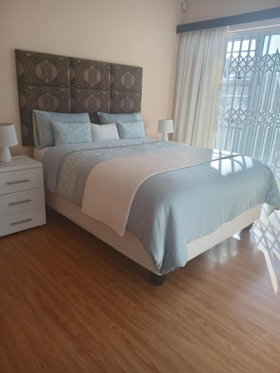 a bedroom with a large bed and a wooden floor at Buliso Homestay in Amsterdamhoek